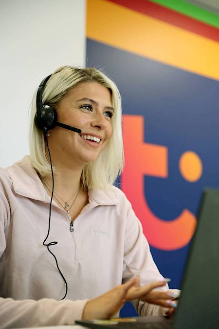 Female customer service agent smiling wearing headset