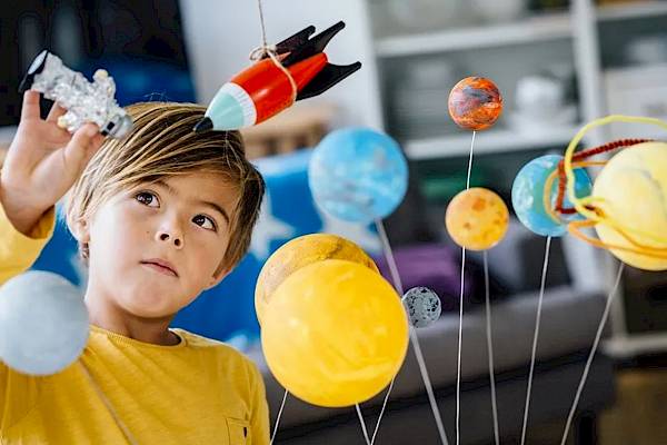 young child looking at planet model