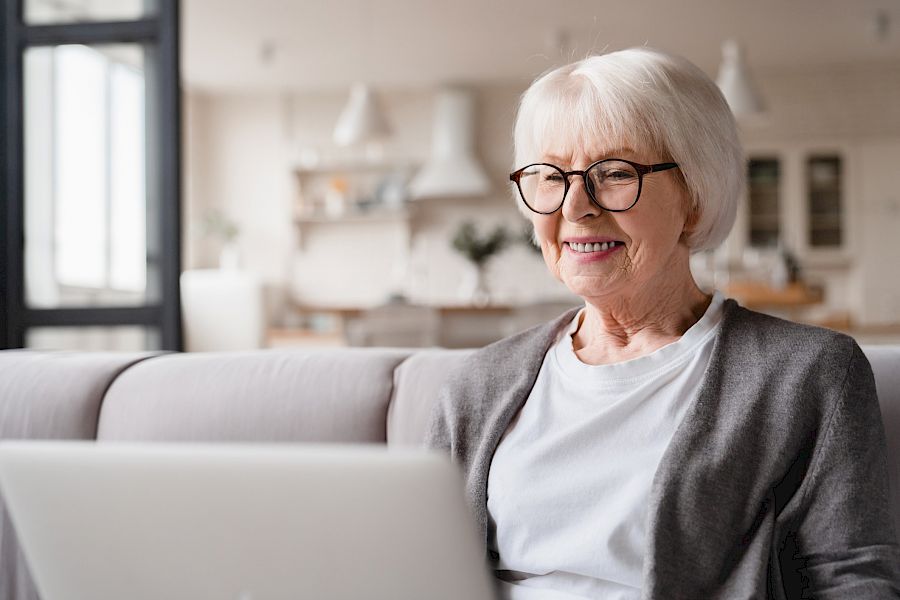Middle aged woman looking at laptop and smiling