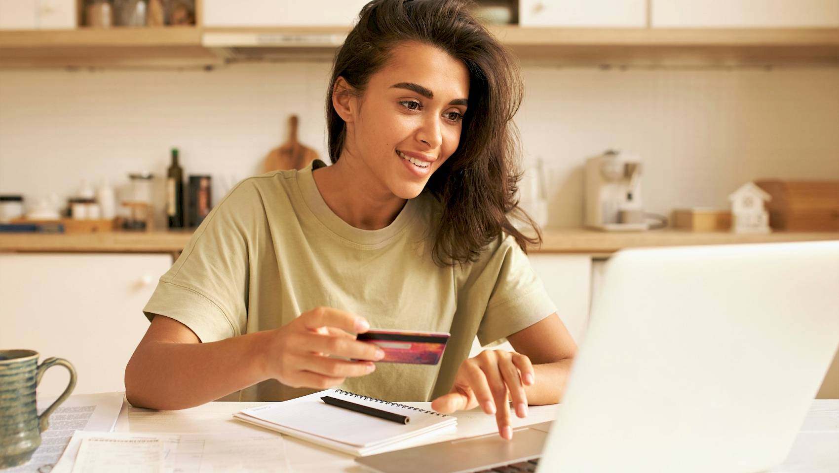 Young female making a puchase via laptop and inputting credit card details