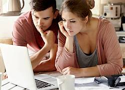 Young couple looking at laptop intently