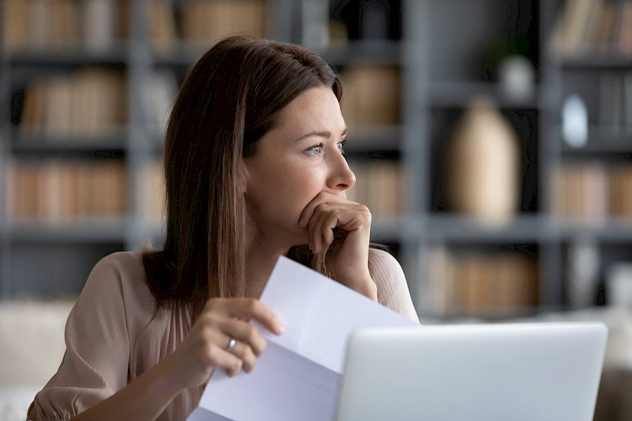 Woman looking concerned in front of laptop