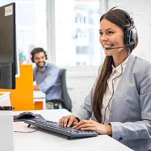 Female in call centre with headset, smiling