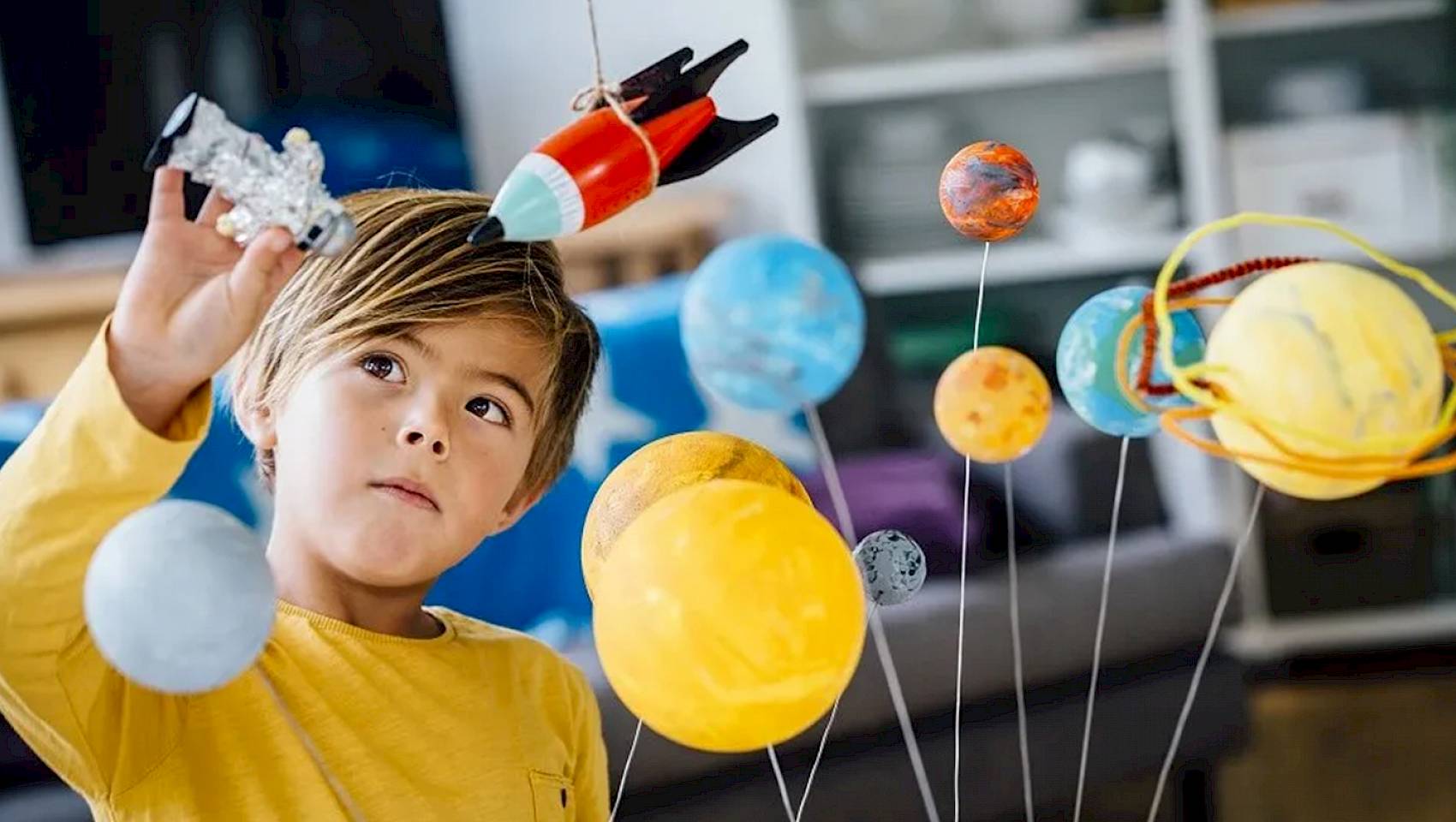 young child looking at planet model