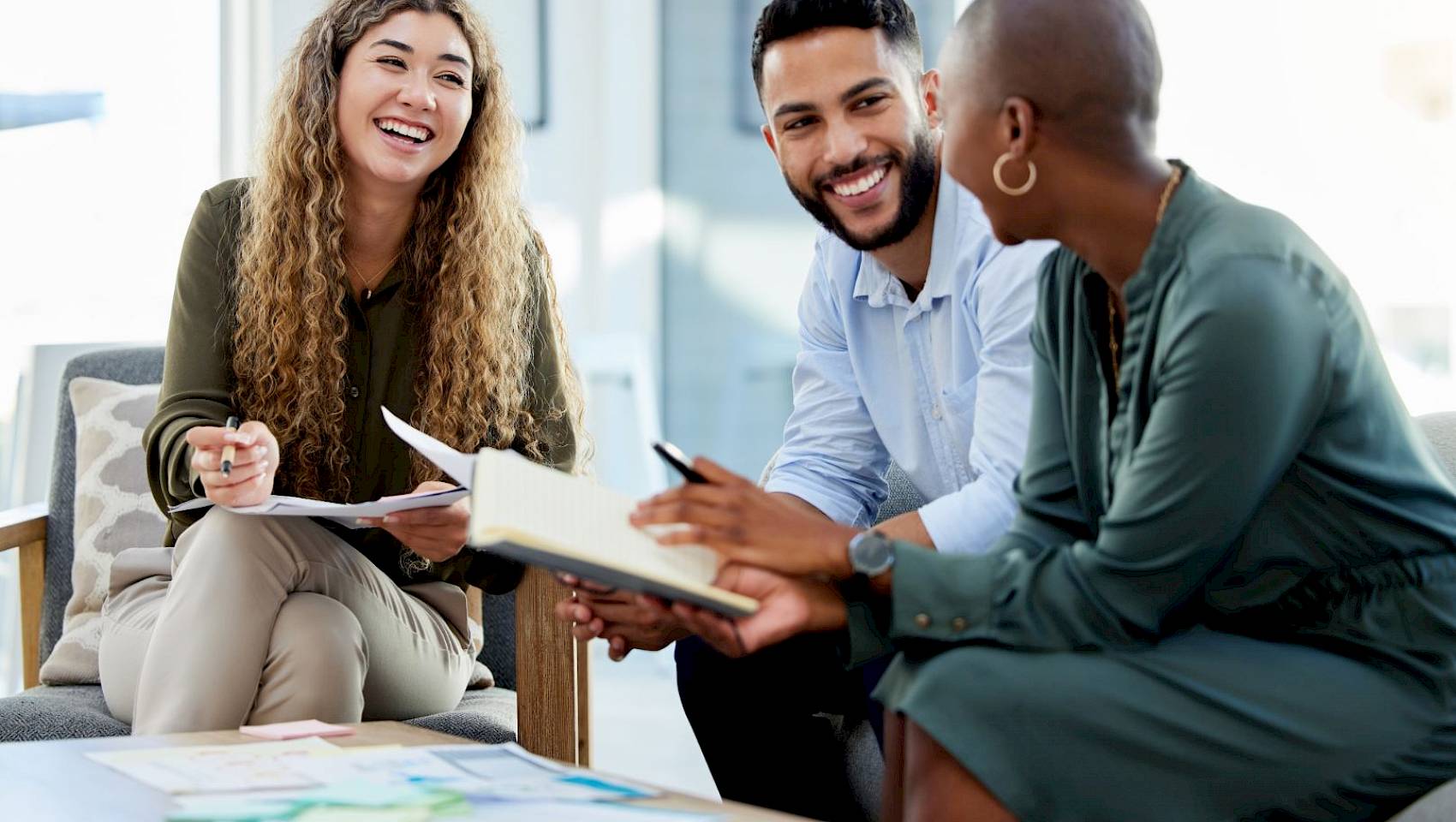professional male and female team talking and smiling in office setting