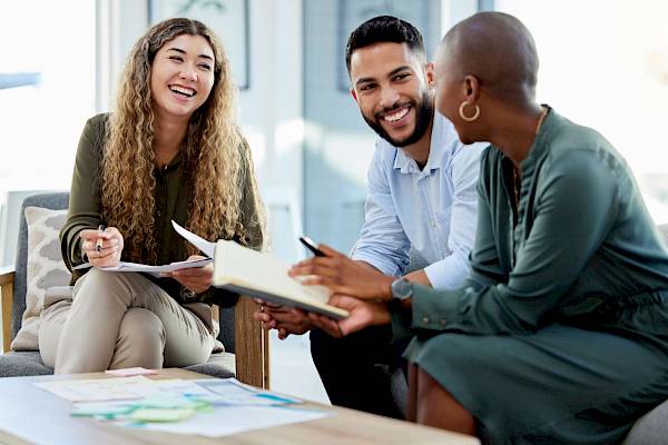 professional male and female team talking and smiling in office setting