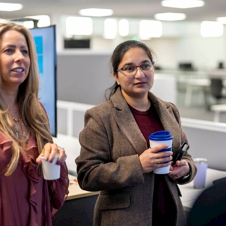 Two female professional colleagues drinkinf coffee and concentrating