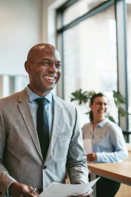Professional male in meeting smiling holding a piece of paper