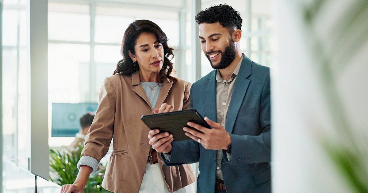 Professional female colleagues smiling and looking at ipad together