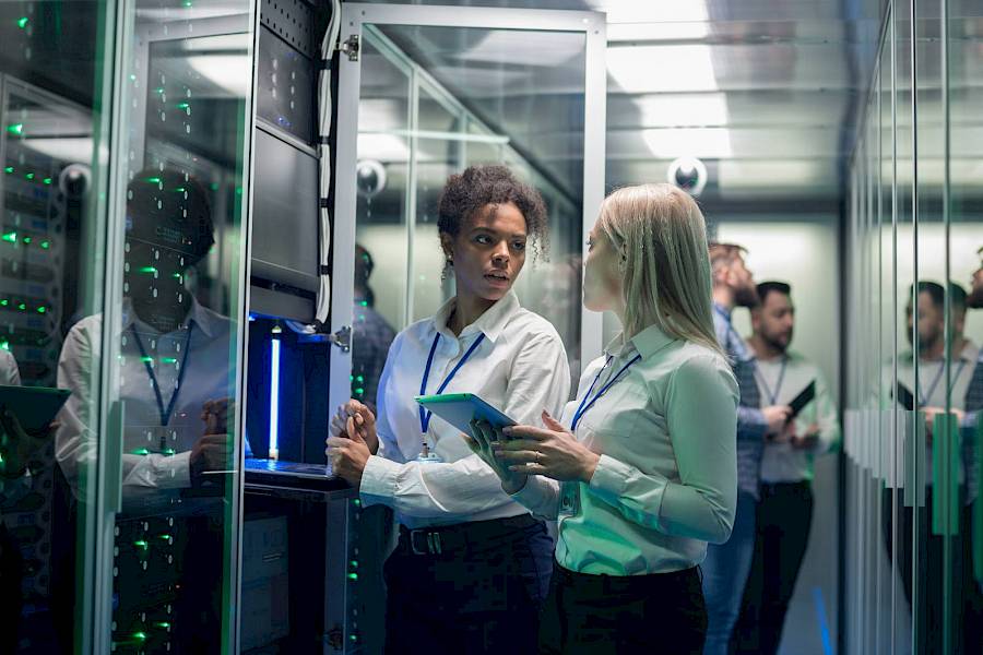 Professional male and female in server room
