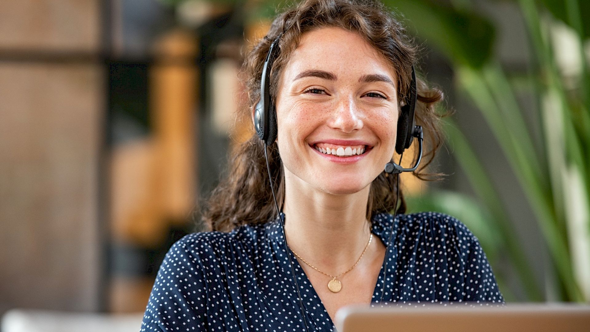 Young customer services representative, wearing a headset and smiling